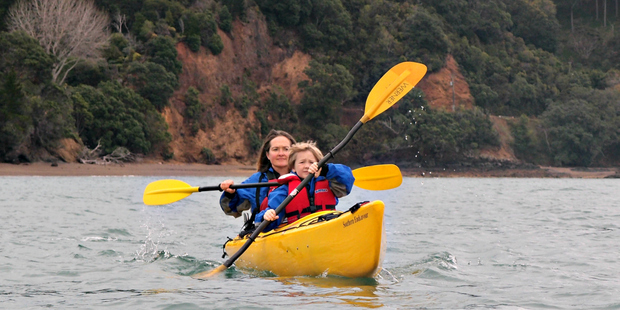 Elisabeth Easther and son take to the water; kayaks on the beach at Tawhitokino campground. Photo / Nic Mead