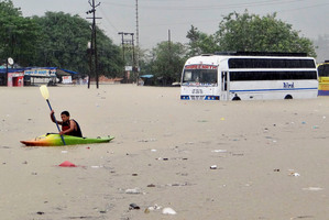 A man rows past a bus partly submerged in flood water in Rishikesh, in the northern Indian state of Uttarakhand, India. Photo / AP