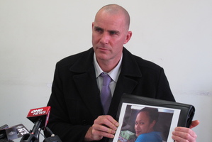 Detective Senior Sergeant Rhys Johnston with a photo of missing Northland woman Barbara Moka.