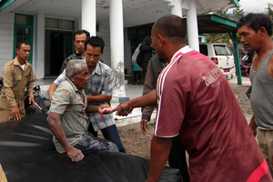 Acenese men assist an earthquake victim to receive medical treatment outside a community health center in Bener Meriah, Aceh province, Indonesia. Photo / AP