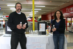 Anti-fluoride campaigners Mark Atkin and Mary Byrne offer free bottles of artesian water at Wainuiomata Mall. Photo / Jamie Adams