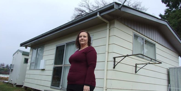 Alycia Burke stands in front of the cabin in which she and her young family live. It will be removed to make room for a 10-house development. Photo / Christina McDonald