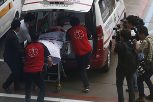 A passenger on the crashed Asiana Airline's aircraft is stretchered.Photo / AFP