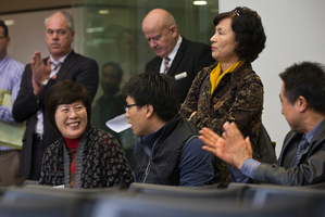 Choon-ok Lee talks with her son Peter Bae after they successfully bid for a home in Swanson which they will rent out. Photo / NZ Herald