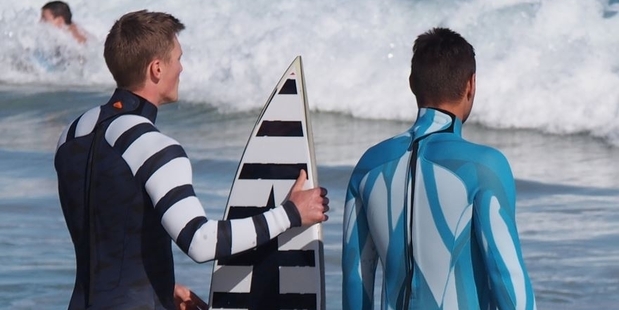 The wetsuits use bold black-and-white and aqua banding patterns to repel sharks.