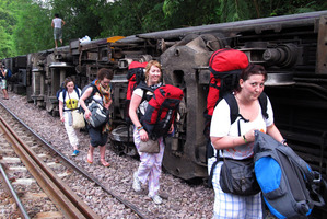 Passengers carry their belonging as they leave form a derailed train in Phrae province, northern Thailand. Photo / AP