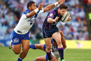 Sam Perrett and Krisnan Inu of the Bulldogs tackle Ben Hampton of the Storm during the round 18 NRL match between Canterbury Bulldogs and the Melbourne Storm. Photo / Getty Images.