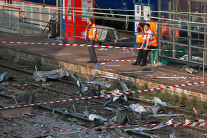 Railway's employees look at the scene where a train derailed at a station in Bretigny sur Orge, south of Paris.Photo / AP