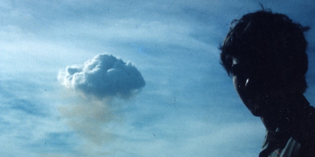 A sailor is silhouetted against a rising mushroom cloud, while aboard the HMNZ Otago in a 1973 protest against French nuclear testing in the Mururoa Atoll.