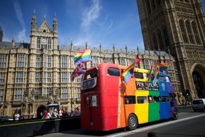 Gay campaigners drive a bus past the Houses of Parliament as the Marriage (Same Sex Couples) Bill gets an unopposed third reading by the Lords in central London. Photo / AFP
