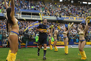 Boca Juniors' Rolando Schiavi enters the field as fans - and cheerleaders - go wild. Buenos Aires' most famous football club attracts the most fervent supporters in the world for any sport. Photo / AP