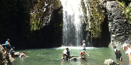 Children play in the water at the foot of the Kitekite Falls. Photo / Supplied