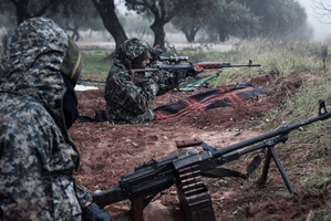 Syrian rebel fighters take their positions on the front line of the ongoing battle for the military airport in Taftanaz, Syria. Photo / AP