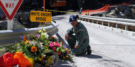 A miner laying down flowers at the White Knight Bridge near the entrance to the Pike River mine. Photo / AP