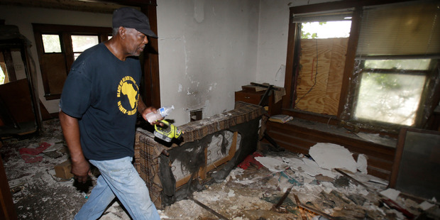 Calvin Brooks searches a house in Cleveland. Photo / AP