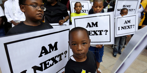 Alvin Duplessis, 10, left, and Thomas McGriff, 5, foreground, hold signs with others from the Watson Memorial Teaching Ministries Church of New Orleans. Photo / AP