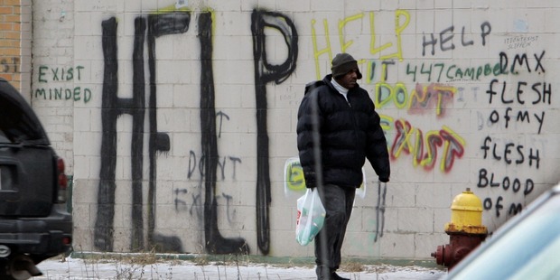 A pedestrian walks by graffiti in downtown Detroit. Photo / AP