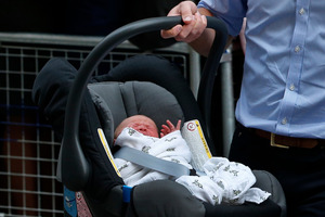 Britain's Prince William carries his son the Prince of Cambridge into a car outside St. Mary's Hospital exclusive Lindo Wing in London. Photo / AP