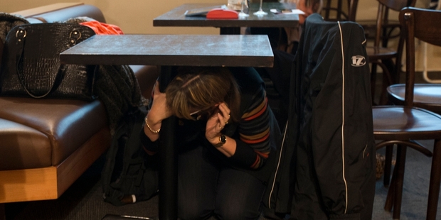 People take refuge under tables at Wellington Airport during the quake. Photo / Greg Bowker