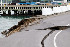 Large cracks are seen in the road near where the land fell into the sea at the Port Wellington Container terminal. Photo / AFP