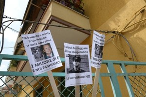 Banners against former German SS officer Erich Priebke reading'he costs us 1 million euros each year' outside his home where he is under house arrest. Photo / AFP
