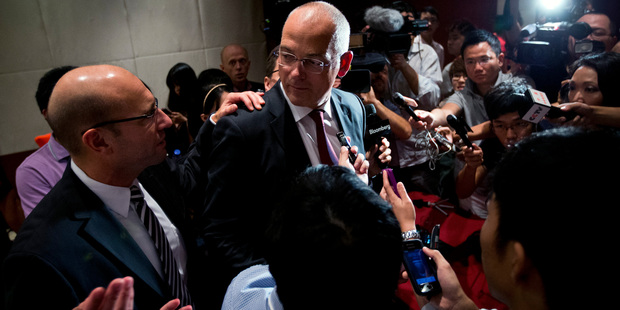 Fonterra chief executive Theo Spierings, center, looks at his managing director of China/India Kelvin Wickham as they are surrounding by Chinese media. Photo / AP