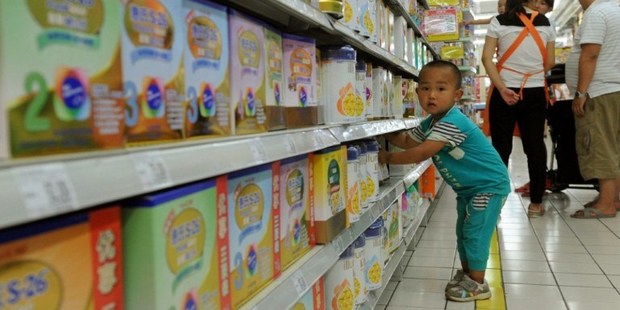 A toddler plays in the imported baby products section while his parents purchase baby products in a Beijing supermarket. Photo / AFP