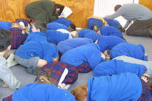Children and staff drop, cover and hold as they've been taught at St Mary's School, Carterton, during today's 6.2 quake. Photo / Gerald Ford