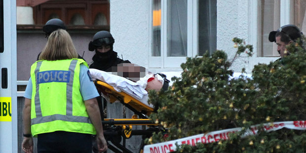 A critically injured man is stretchered away after being accidentally shot by police. Photo / Hawkes Bay Today