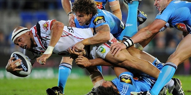 Sam Rapira is tackled by Titans players in the round 24 clash between the Warriors and Gold Coast. Photo / Getty Images