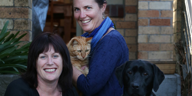 Kim Edwards with her cat Rory and Michelle Whitmore and her dog Maci. The dog provided blood for Rory when he was sick. Photo: Joel Ford