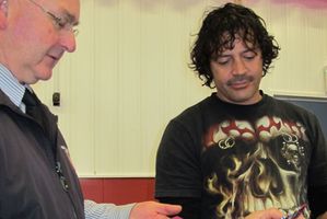Waihi College principal, Alistair Cochrane, has a look at Willie Apiata's medals. Photo / Fritha Tagg of the Waihi Leader