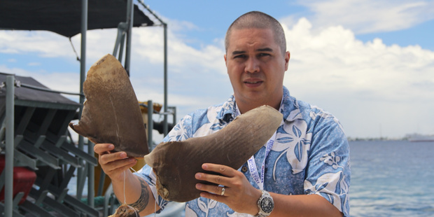 Pew Environment Group shark conservationist Angelo Villagomez throws seized shark fins, worth thousands of dollars, into the sea at Majuro.