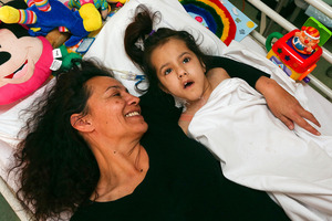 Kathleen McKay lies with her terminally ill daughter, Brennagh, in Wellington Hospital. Photo / Getty Images