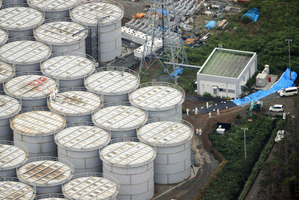 Workers stand on storage tanks at the Fukushima Dai-ichi nuclear plant at Okuma town in Fukushima prefecture, northeastern Japan. Photo / AFP