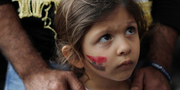 A girl with the Syrian flag painted on her cheek attends a demonstration by adults protesting any military action in Syria by the U.S., outside the U.S. embassy in Caracas, Venezuela. Photo / AP