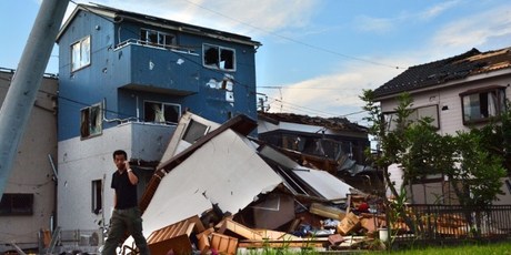 A man walks past damaged houses after a tornado tore through parts of the city of Koshigaya, Saitama prefecture. Photo / AFP