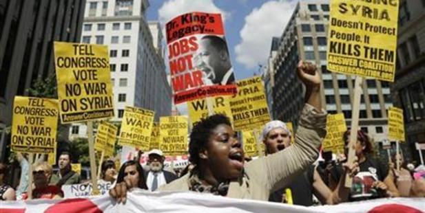 Kerbie Joseph yells and pumps her fist as she marches with protesters against U.S. military action in Syria through Washington to Capitol Hill from the White House. Photo / AP