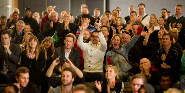 A crowd of 1,000 Emirates Team NZ fans celebrate their team's victory in race six at Shed 10 on the Auckland waterfront yesterday. Photo / Richard Robinson