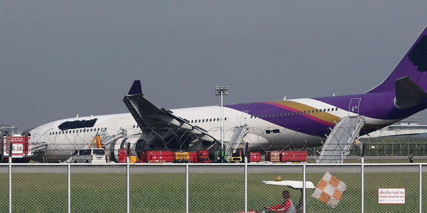 An airport worker drives a cart past a damaged Thai Airways Airbus A330-300 at Sunvarnabhumi International Airport in Bangkok. Photo / AP