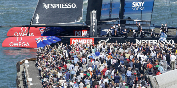 Emirates Team New Zealand crew members wave to fans after defeating Oracle Team USA. Photo / AP