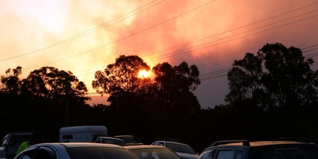 Residents wait at a gas station while bushfires erupt in Sydney's western suburb of Castlereagh. Photo / AFP