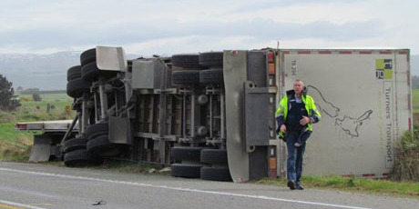 A truck lies facing the opposite way it was heading on State Highway 1 north of Dunedin, after being blown over. Photo / ODT