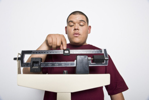 Teenage (16-17) boy using weight scales