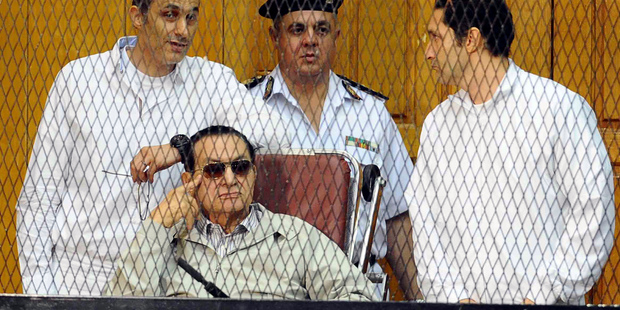 Former Egyptian President Hosni Mubarak, seated, and his two sons Gamal Mubarak, left, and Alaa Mubarak, right. Photo / AP
