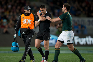 All Blacks 1st-five Daniel Carter walks off injured, as South African hooker Bismarck du Plessis has a word. Photo / Brett Phibbs