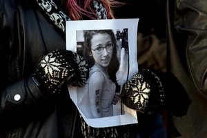 A woman holds a photo at an April community vigil to remember Rehtaeh Parsons. Her parents are outraged a dating site used her image for advertising. Photo / AP