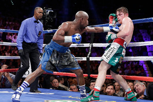 Floyd Mayweather Jr. throws a jab against Canelo Alvarez against the ropes in the eighth round during a 152-pound title fight, Saturday, Sept. 14, 2013, in Las Vegas. (AP Photo/Eric Jamison)