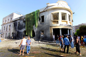People gather to look at the site of a car bombing in Benghazi, Libya.