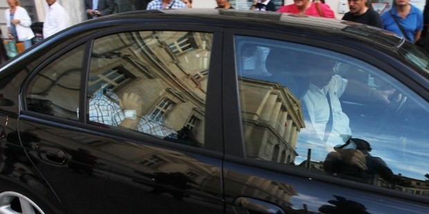 Stephan Turk (back seat), who killed a thief who had broken into his jewelry store, hides his face as he leaves the courthouse in Nice, on September 13, 2013. Photo / AFP